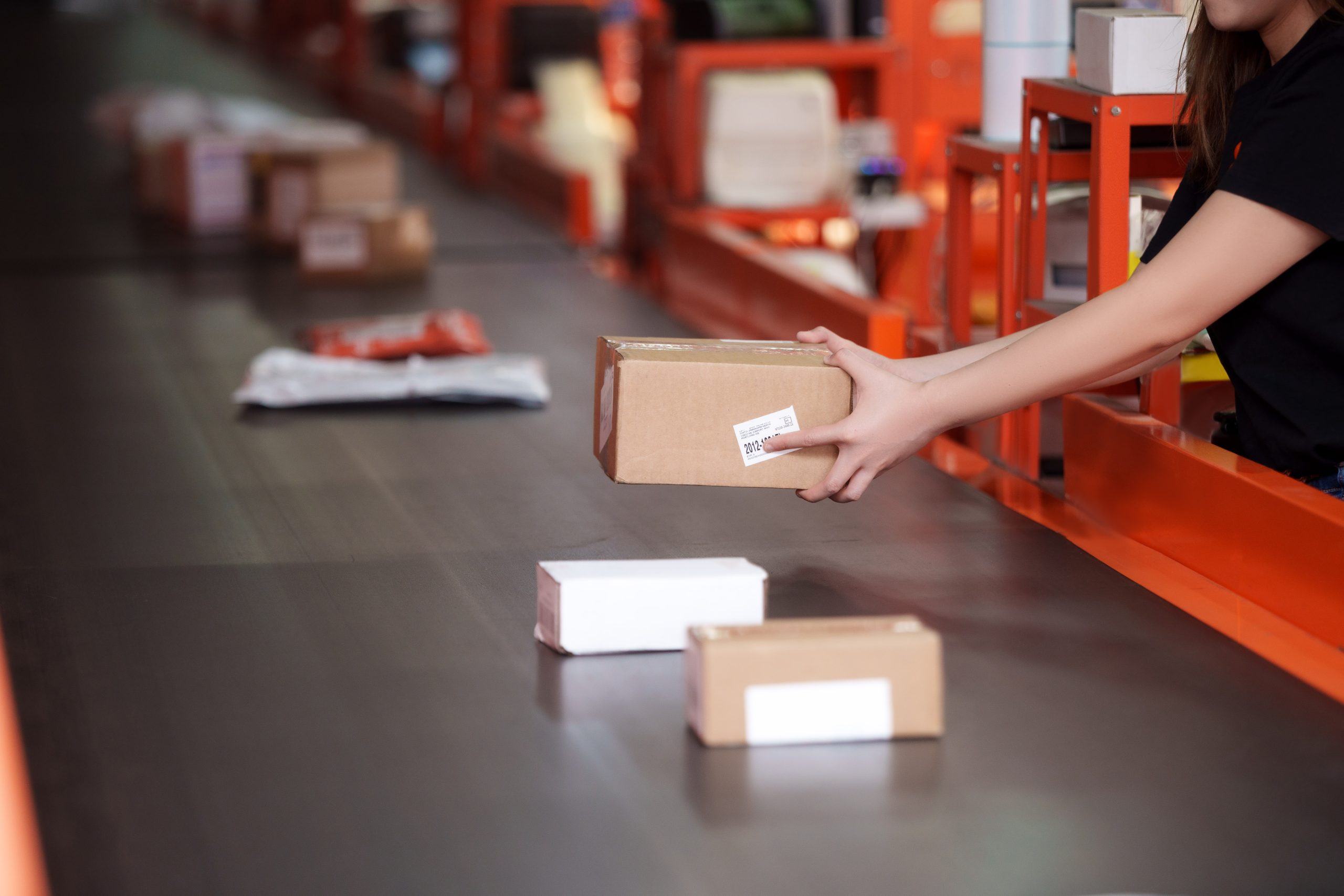 Staff placing a parcel on the sorting conveyor line